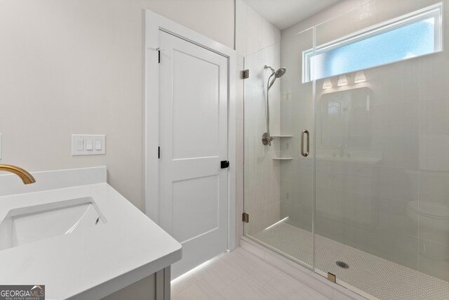 bathroom with vanity and a shower with door