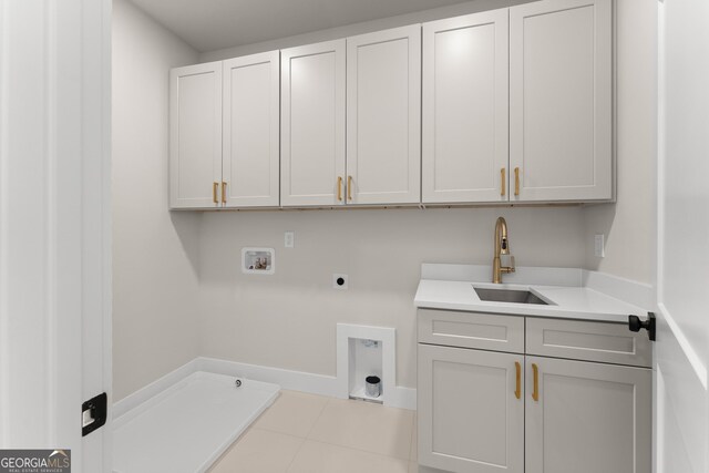 washroom with sink, washer hookup, cabinets, hookup for an electric dryer, and light tile patterned flooring