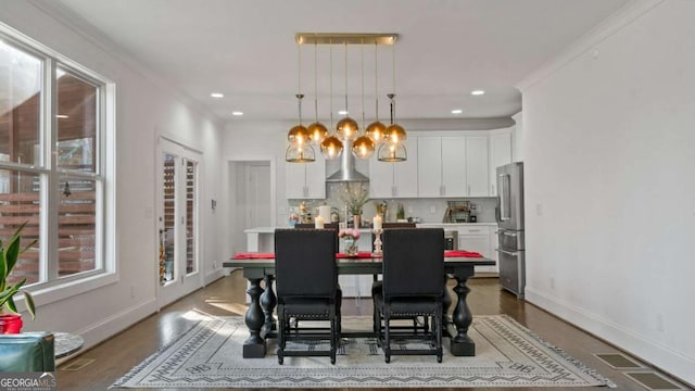 dining room with crown molding and hardwood / wood-style floors