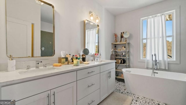 bathroom featuring tile patterned floors, a bathtub, and vanity