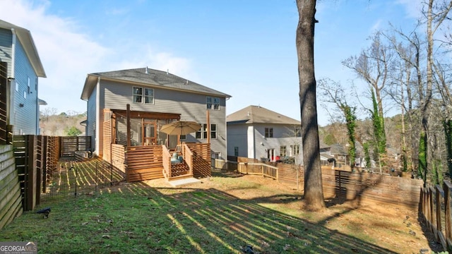 rear view of property with a wooden deck and a yard