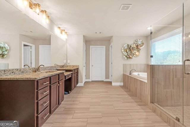 bathroom featuring shower with separate bathtub and vanity