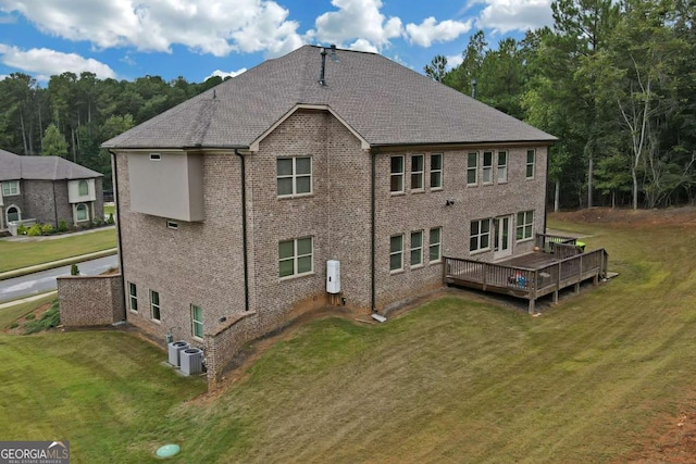 back of house featuring a wooden deck, a yard, and central AC