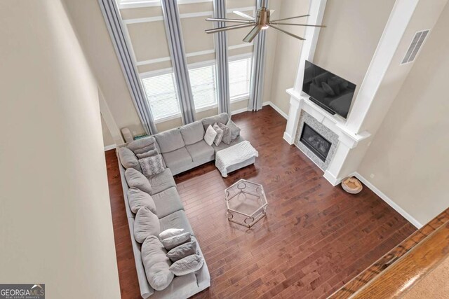 living room with ceiling fan and dark wood-type flooring