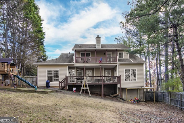 back of property with a balcony and a playground