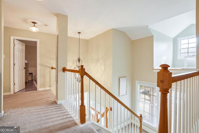 stairway with carpet, plenty of natural light, and lofted ceiling