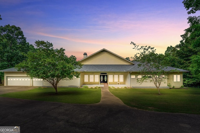 view of front of home featuring a yard, french doors, and a garage