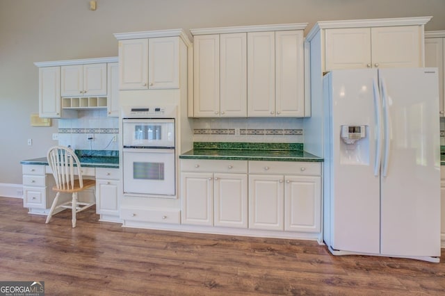 kitchen featuring white appliances, tasteful backsplash, white cabinetry, and dark wood-type flooring