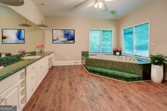 interior space featuring white cabinetry, sink, ceiling fan, pendant lighting, and hardwood / wood-style flooring