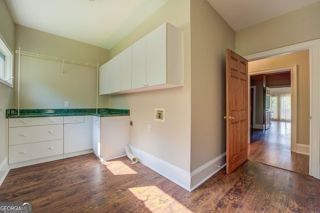 washroom with electric dryer hookup, cabinets, dark wood-type flooring, and washer hookup