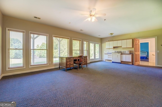 interior space with white cabinets, carpet floors, and ceiling fan