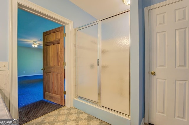 bathroom with ceiling fan and an enclosed shower