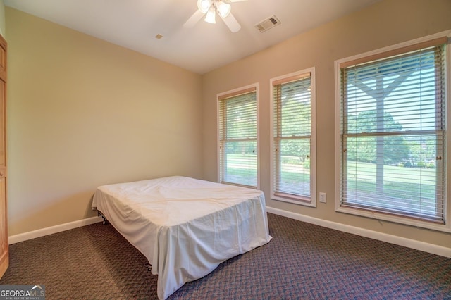 bedroom featuring ceiling fan and dark carpet