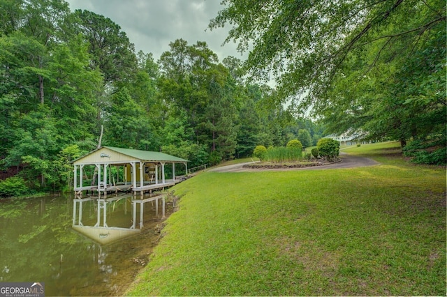 view of yard with a water view and a dock