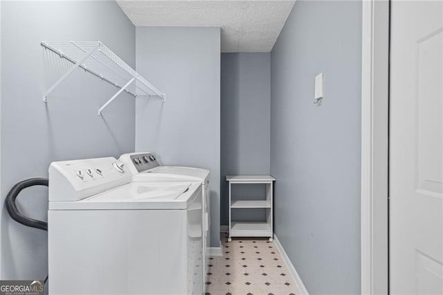 washroom featuring washer and dryer and a textured ceiling