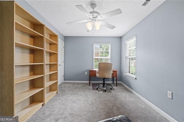 carpeted office space featuring a textured ceiling and ceiling fan