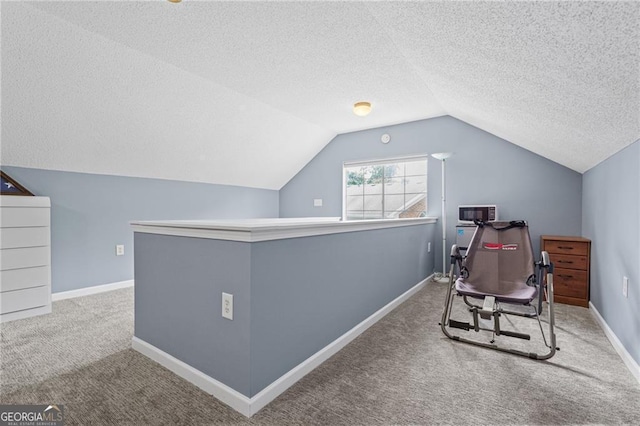 carpeted office space with a textured ceiling and lofted ceiling