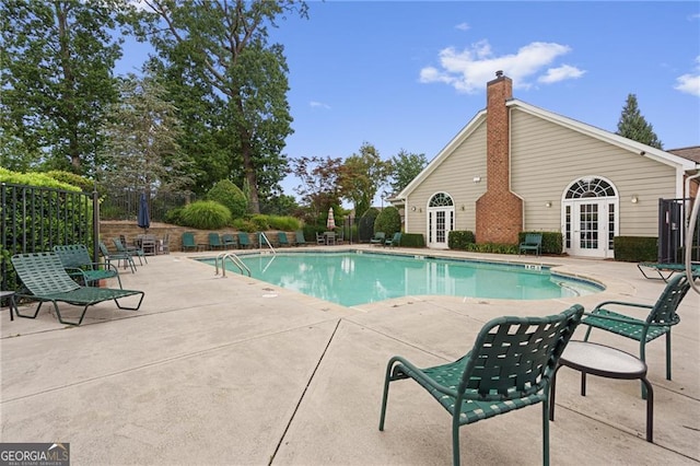 view of swimming pool featuring french doors and a patio