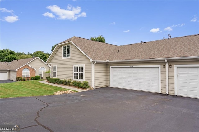 view of front of home with a front yard and a garage