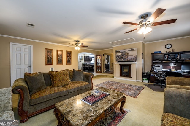 living room featuring ceiling fan, ornamental molding, and carpet flooring