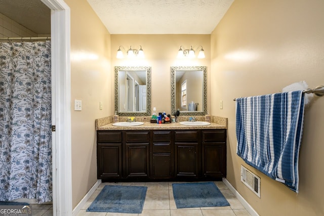 bathroom featuring a textured ceiling, vanity, and tile patterned flooring