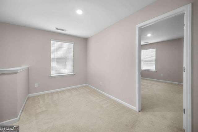 unfurnished room featuring plenty of natural light and light colored carpet