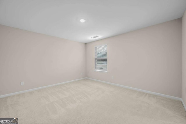 spare room featuring light colored carpet