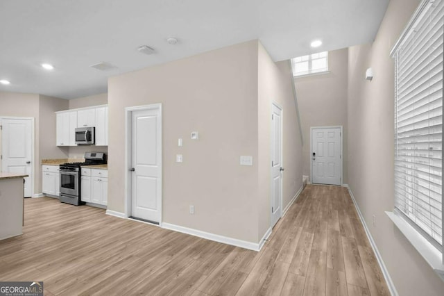 kitchen featuring light hardwood / wood-style flooring, white cabinets, and appliances with stainless steel finishes