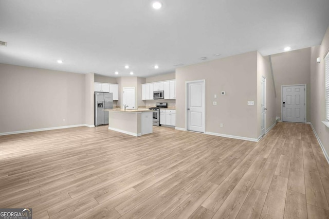 unfurnished living room featuring light hardwood / wood-style flooring and sink