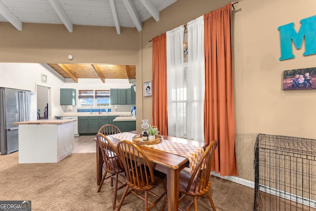 dining space with vaulted ceiling with beams, wood ceiling, and light carpet