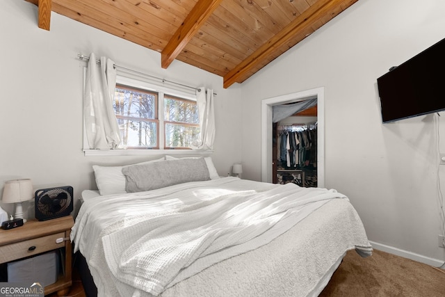 bedroom featuring a spacious closet, lofted ceiling with beams, a closet, carpet, and wood ceiling