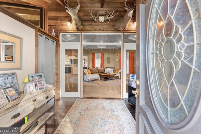 interior space with log walls and dark wood-type flooring