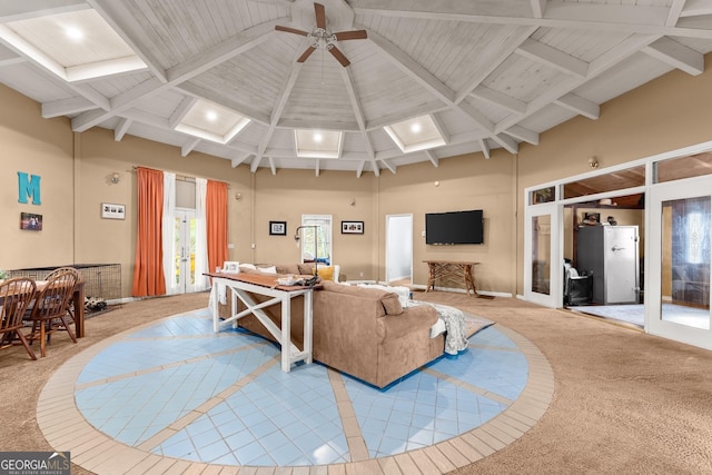 living room with light carpet, beam ceiling, a towering ceiling, and ceiling fan