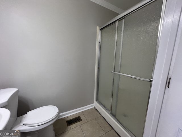 bathroom featuring tile patterned floors, ornamental molding, a shower with shower door, and toilet