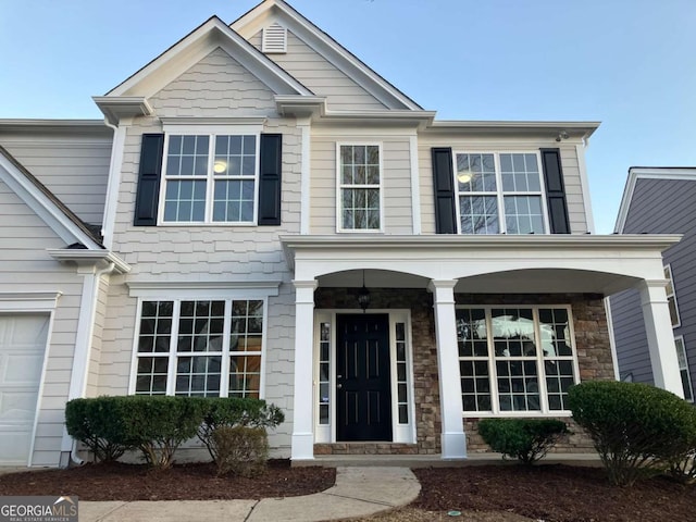 681 Courageous Ct, Lawrenceville, GA 30043 - view of front facade with covered porch, stone siding, and a garage