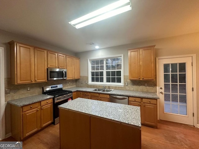 kitchen featuring a center island, stainless steel appliances, backsplash, and sink