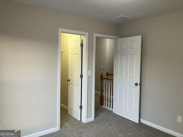 unfurnished bedroom with dark carpet