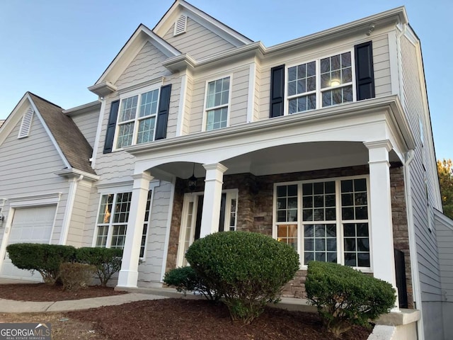 681 Courageous Ct, Lawrenceville, GA 30043 - view of front of home featuring covered porch, a garage, and stone siding