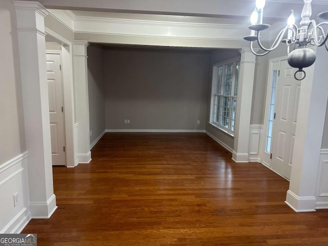 681 Courageous Ct, Lawrenceville, GA 30043 - unfurnished dining area with a chandelier, wood finished floors, crown molding, and ornate columns