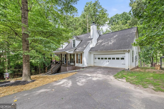 cape cod home with covered porch and a garage