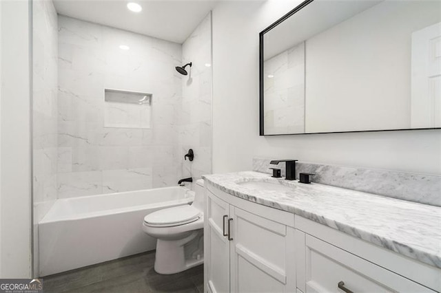 full bathroom with toilet, wood-type flooring, vanity, and tiled shower / bath combo