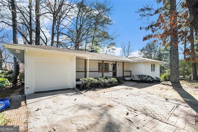 single story home featuring a porch and a garage