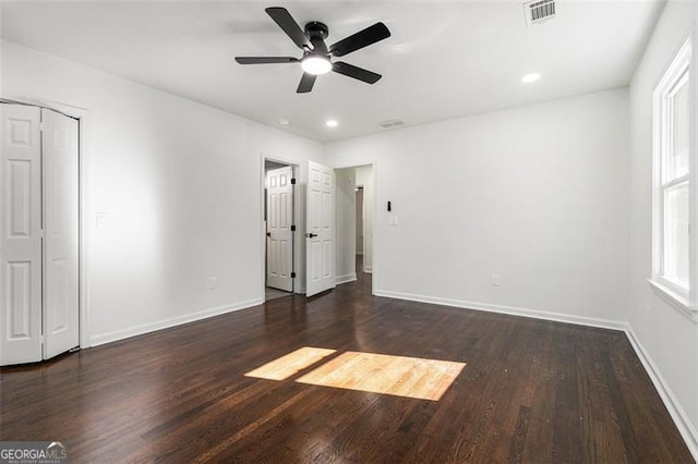 unfurnished bedroom with ceiling fan, a closet, and dark wood-type flooring