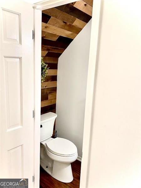 bathroom with toilet and wood-type flooring