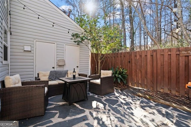 view of patio with an outdoor living space with a fire pit