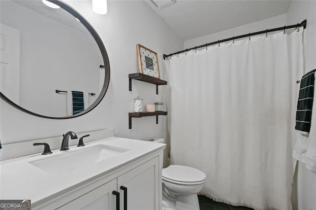 bathroom with tile patterned floors, vanity, toilet, and a textured ceiling