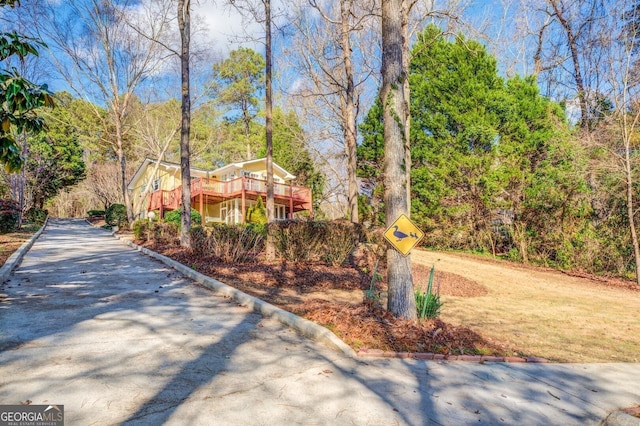 exterior space featuring a view of trees and curbs