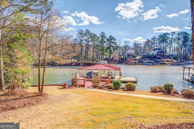 dock area with a gazebo, a yard, and a water view