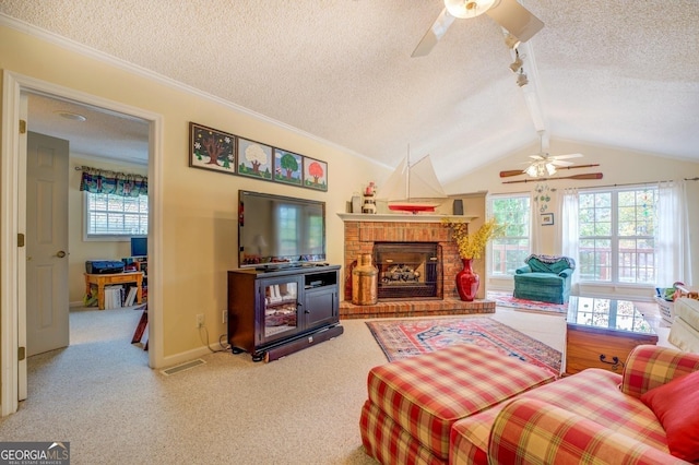 living room featuring lofted ceiling with beams, ceiling fan, a textured ceiling, a fireplace, and carpet