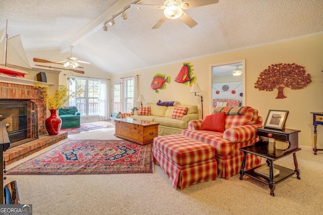 carpeted living area with ceiling fan, vaulted ceiling with beams, rail lighting, a textured ceiling, and a fireplace